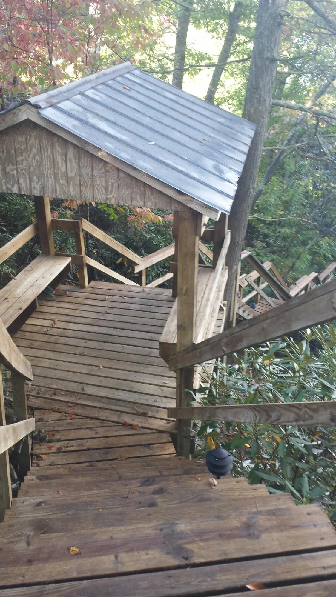 Metal roofed shelter over wooden steps on a wooded walkway — Skylight Repair & Installation work by our crew in New Boston