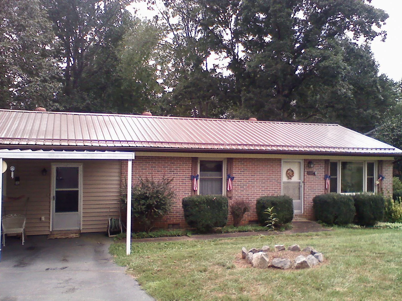 Bronze metal roof and carport on a brick ranch home — Roof Repair work by our crew in New Boston